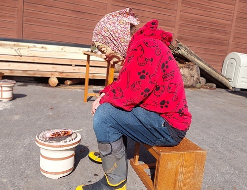 被りものをつけてソーセージを焼くスタッフの画像