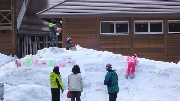 スタッフ手作りのすべり台で遊ぶ参加者の様子