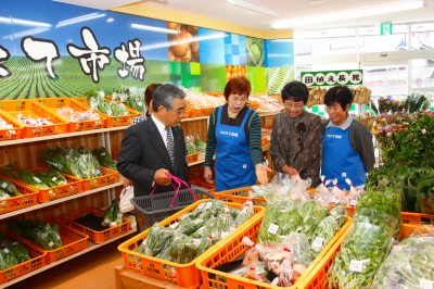 産直市で新鮮な野菜や加工品を購入する知事