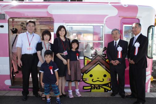 電車の前で記念撮影（左から、地元小学生の後藤さん、山本さん、昌子社長）
