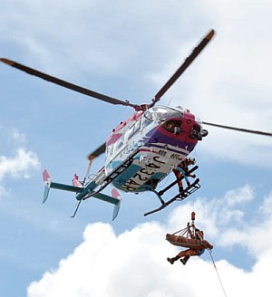 負傷者役を収容する県防災ヘリコプター「はくちょう」（訓練）の画像