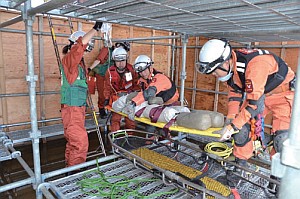 倒壊した建物内で、負傷者役の応急処置をしながら救助する消防隊員とＤＭＡＴ隊員（訓練）の画像