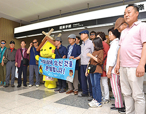 県観光キャラクター「しまねっこ」と記念撮影する韓国人観光客の写真