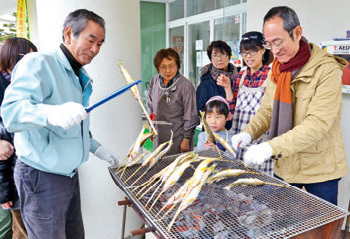 アユの塩焼きづくりを教える土山幸延理事長の写真