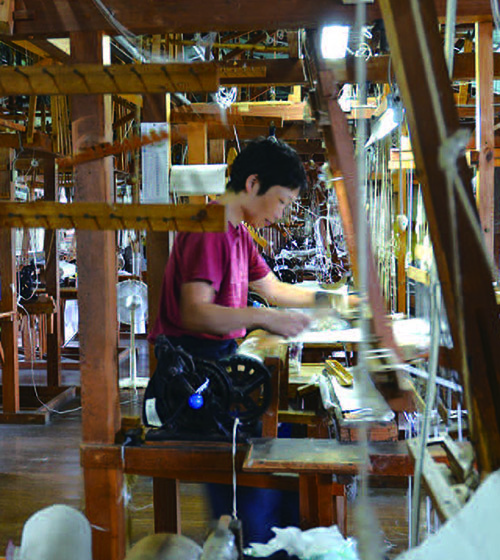 出産前と同様、機織り作業に取り組む武元直子さんの写真