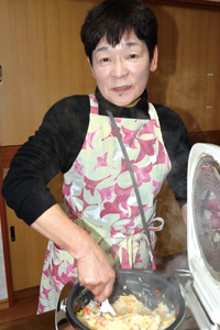炊き上がった「島田タケノコご飯」を混ぜ込む岩崎静枝さんの写真