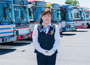 バスの前で笑顔の安井さんの写真