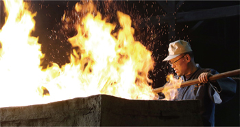 砂鉄を装入する堀尾氏の写真