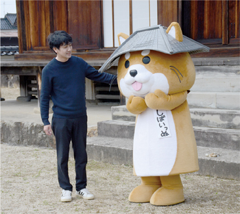 自身が考案したキャラクター「しばいっぬ」と柴田さんの写真