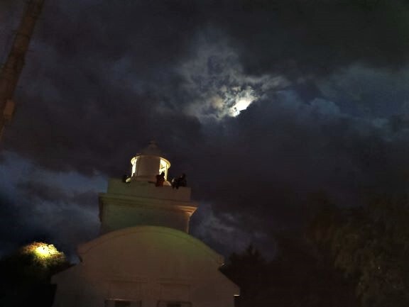 夜空の月と灯台の光り