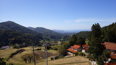 室谷を通る道路から見た棚田と遠くに見える日本海、三隅火力発電所の写真です。