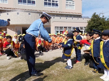 園児に一日おまわりさんをお願いしている様子