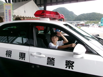 子供がパトカーに乗っている写真